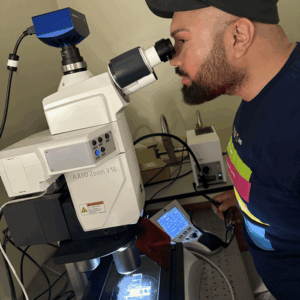 Saul Villegas, looking at lichen under the microscope with the Art+Fog Collective